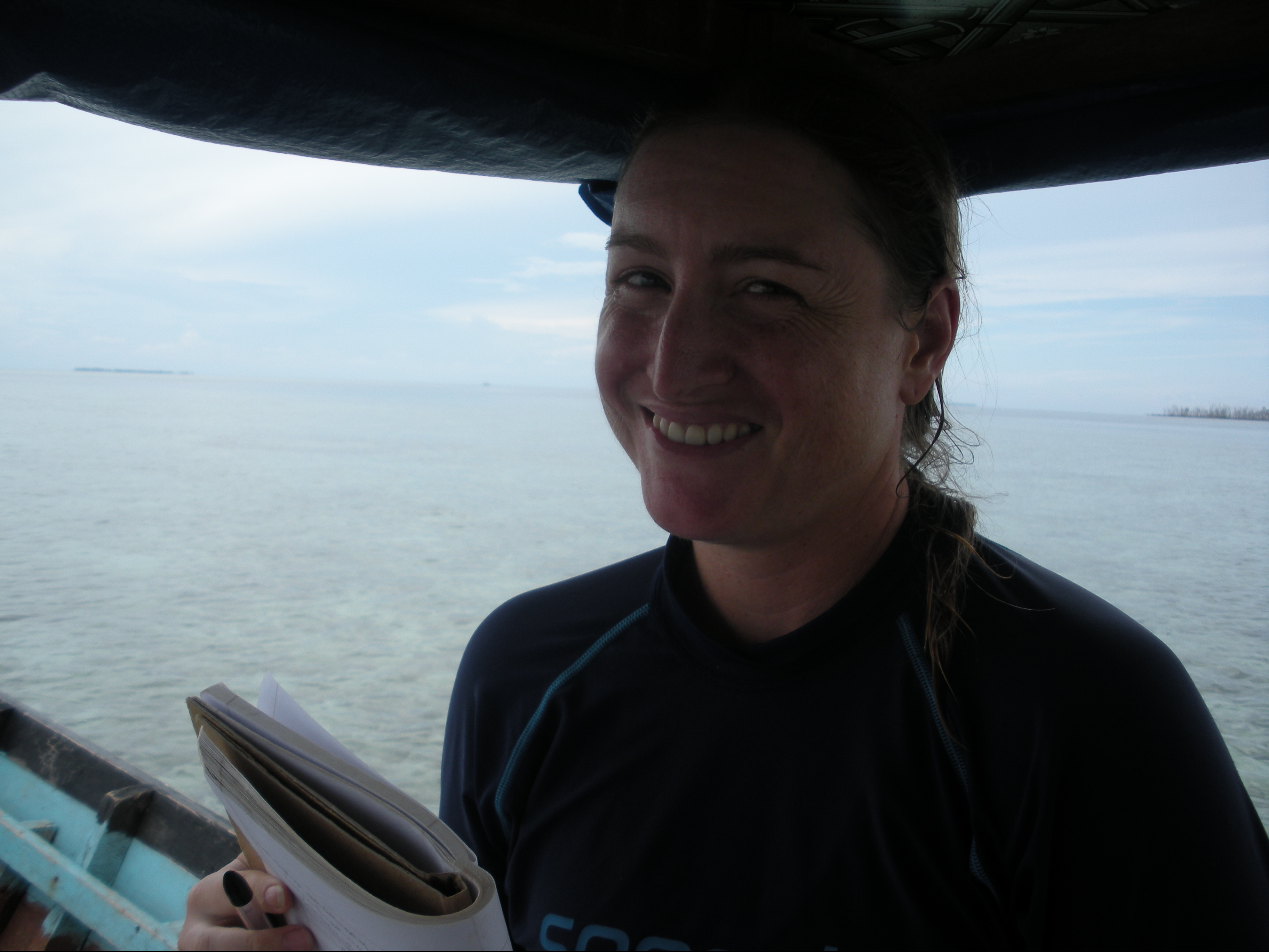 Dr. Quimby on a perahu (small fishing boat), holding a notebook, in Indonesia